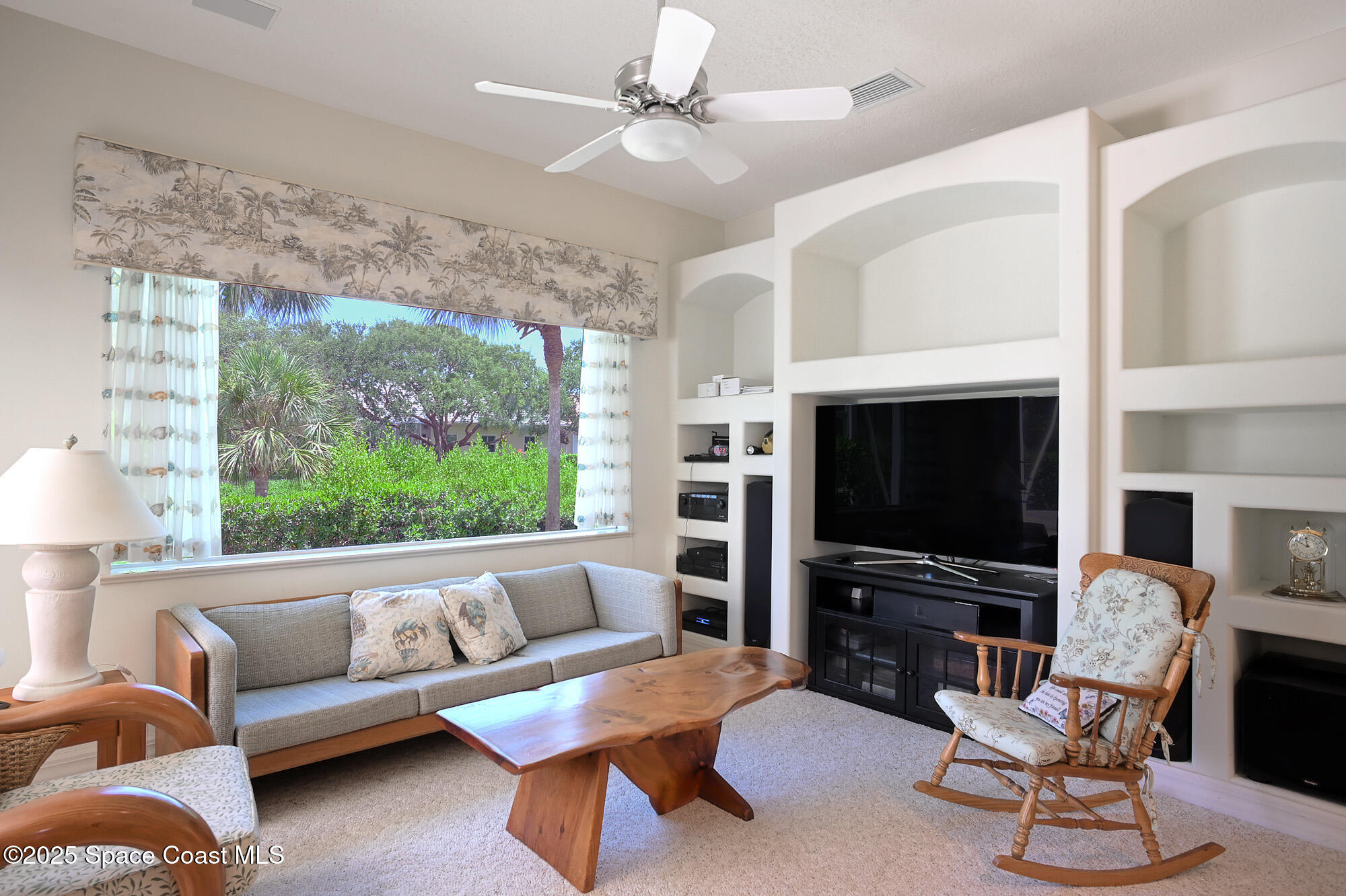5357 Solway Drive Melbourne Beach, FL 32951 - Photo 9 of 31 a living room with furniture a flat screen tv and a fireplace