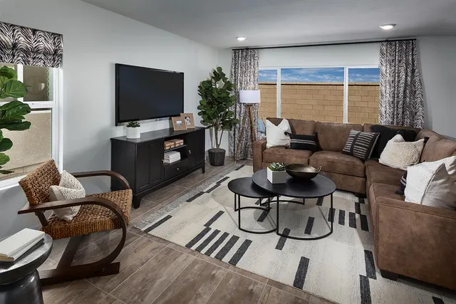 a living room with furniture a flat screen tv and a large window