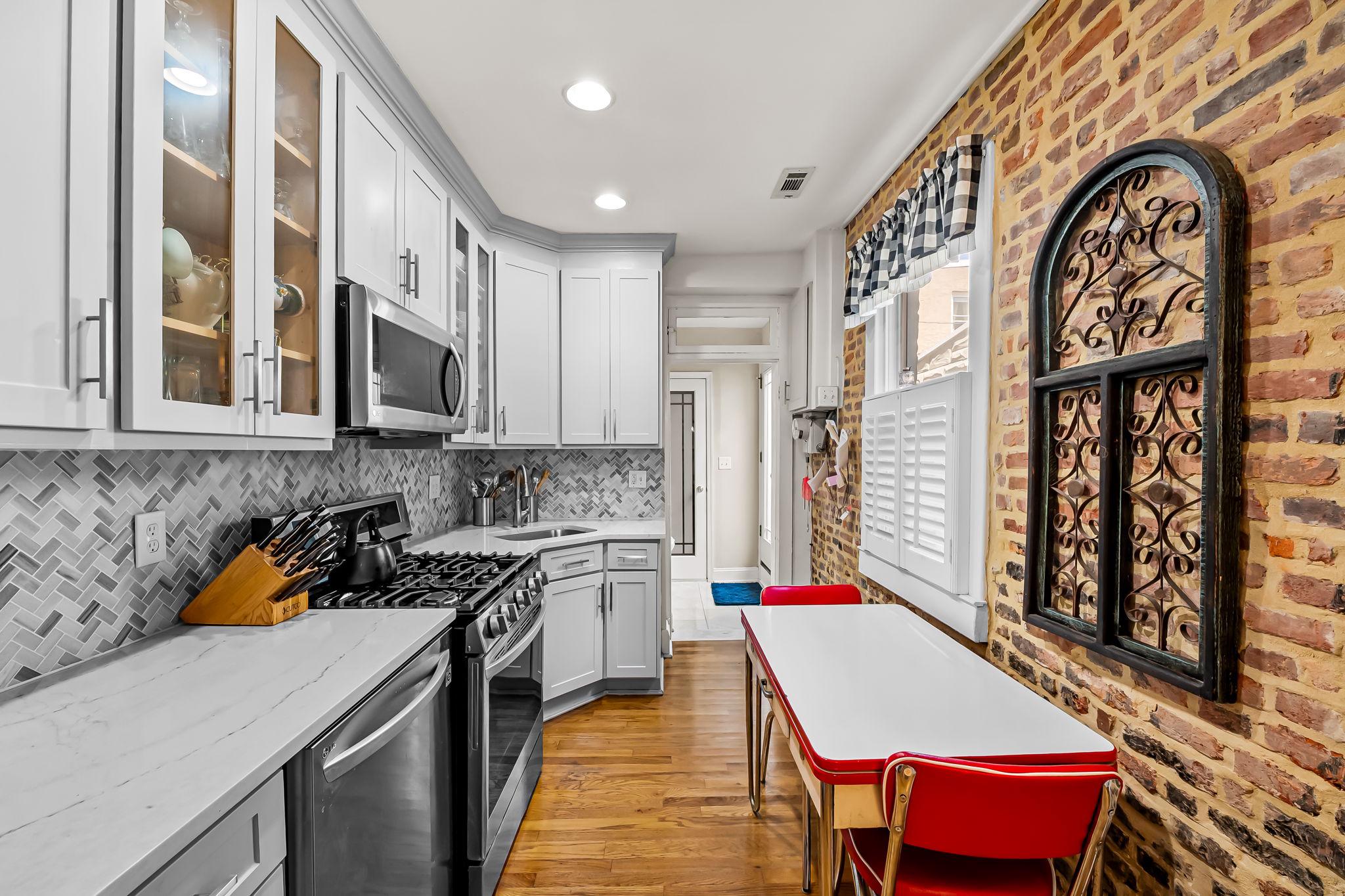 3134 Elliott Street Baltimore, MD 21224 - Photo 12 of 34 a kitchen with stainless steel appliances kitchen island granite countertop a stove a sink and a microwave