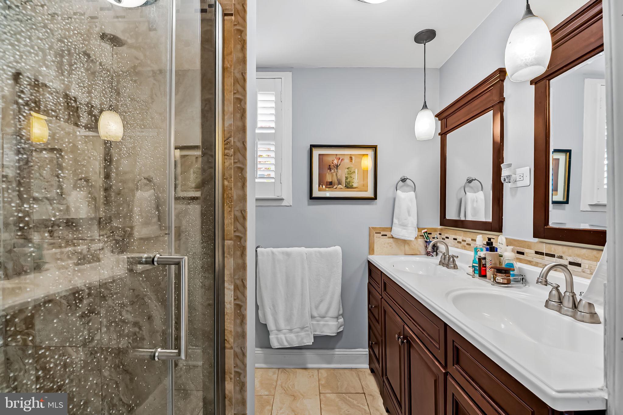 3134 Elliott Street Baltimore, MD 21224 - Photo 15 of 34 a bathroom with a double vanity sink mirror and shower