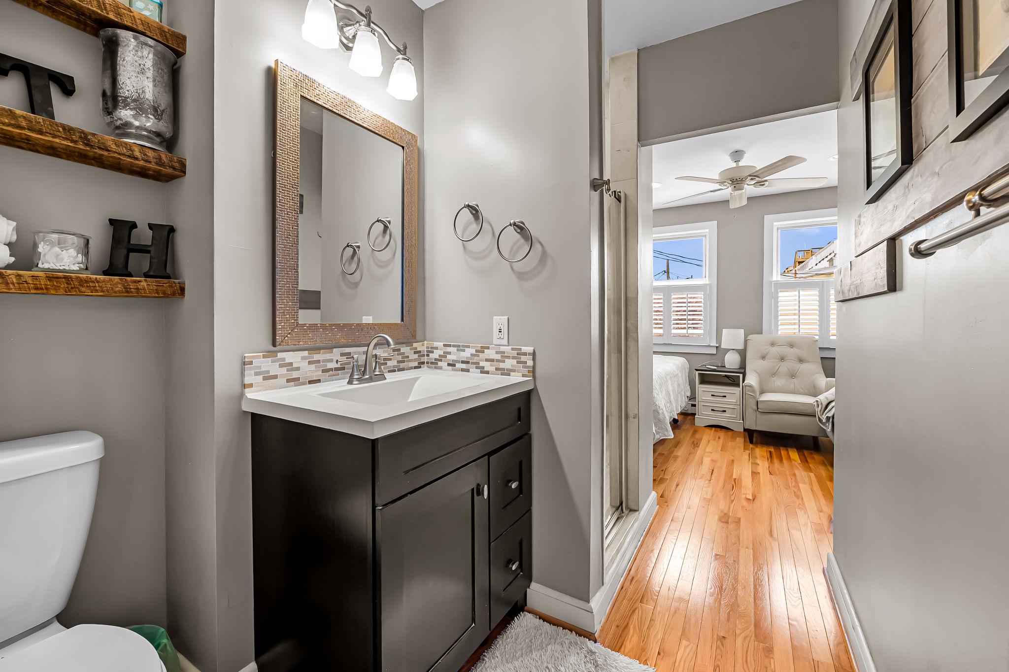 3134 Elliott Street Baltimore, MD 21224 - Photo 21 of 34 a bathroom with a sink a toilet a mirror and shower