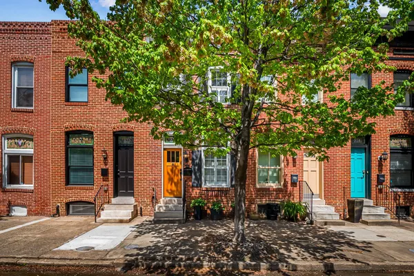 a front view of a house with a tree