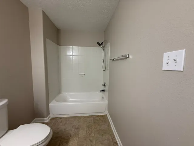 a bathroom with a toilet and a shower
