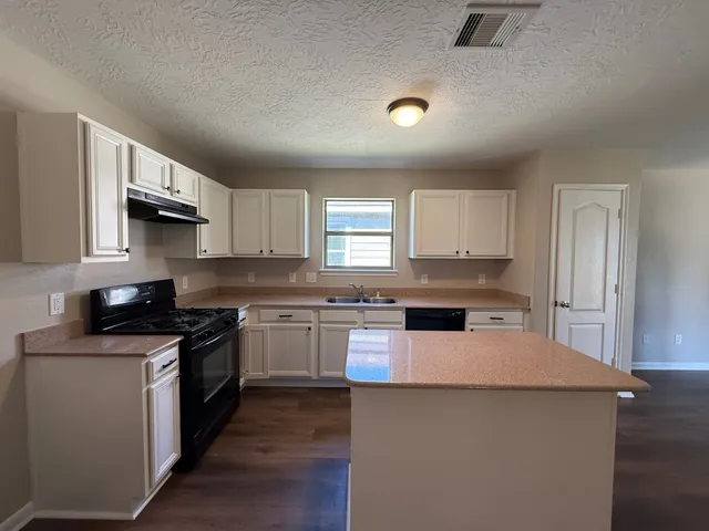 a kitchen with a stove a sink and a refrigerator