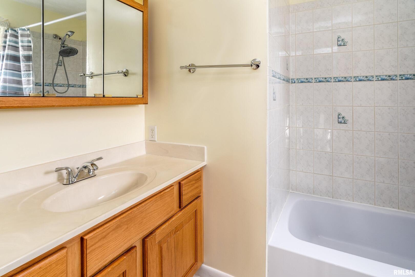 311 Baggott Street Zeigler, IL 62999 - Photo 32 of 38 a bathroom with a granite countertop sink a mirror and a bathtub