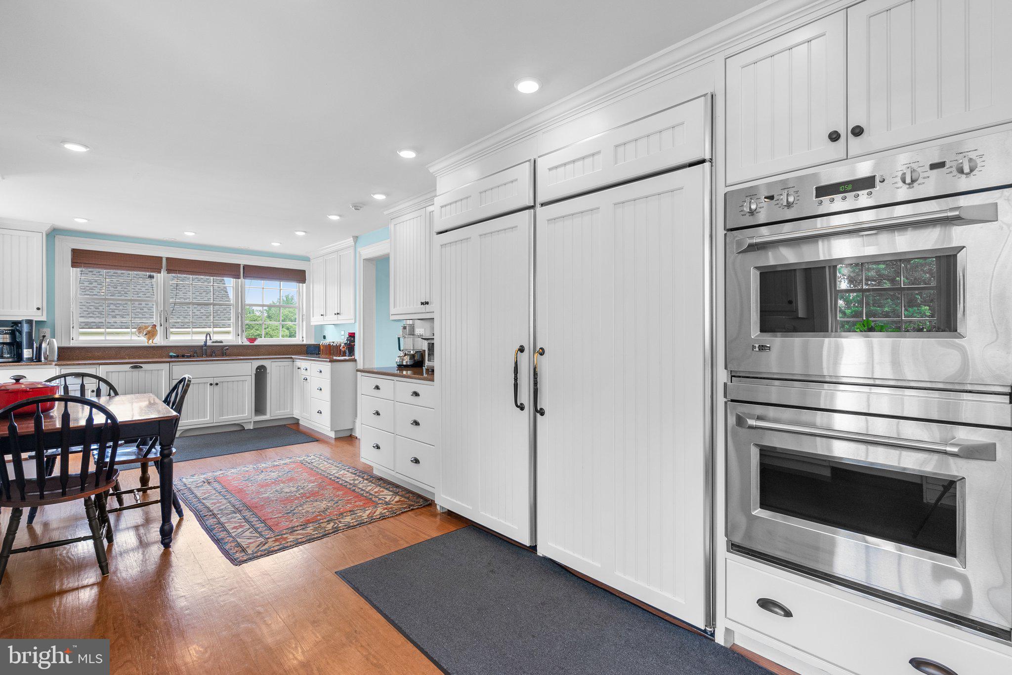 15407 Dr Bowen Road Aquasco, MD 20608 - Photo 18 of 89 a kitchen with stainless steel appliances a stove a refrigerator and white cabinets with wooden floor