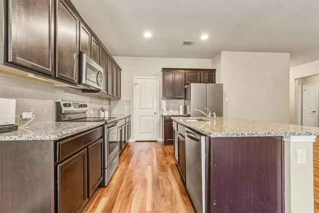 a view of a kitchen with a sink and a refrigerator