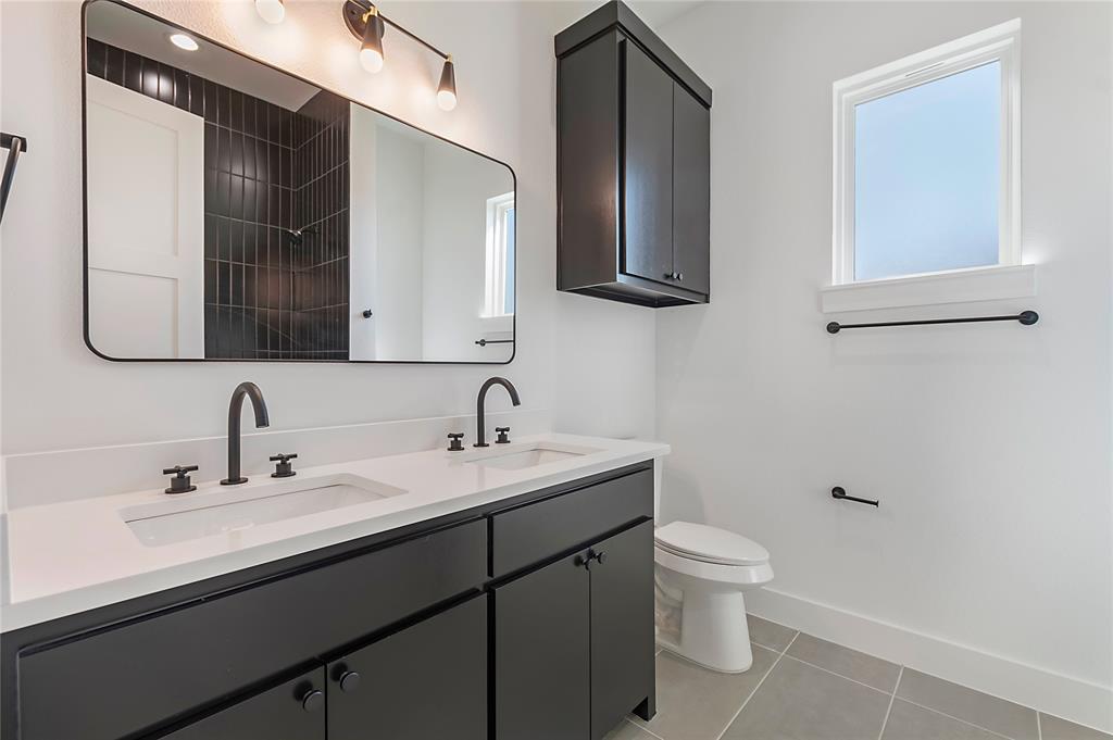430 Whispering Way Red Oak, TX 75154 - Photo 31 of 40 Double vanity with white countertops, matte black faucets, and dark cabinetry