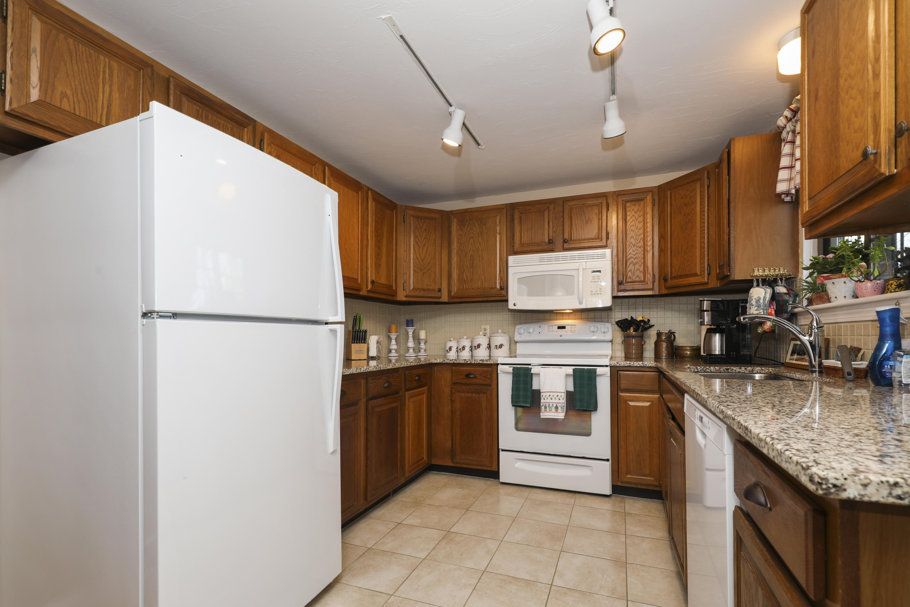 33 West Road, Unit 7B Orleans, MA 02653 - Photo 9 of 24 a kitchen with stainless steel appliances granite countertop a refrigerator a stove a sink dishwasher a microwave oven with granite countertops and cabinets