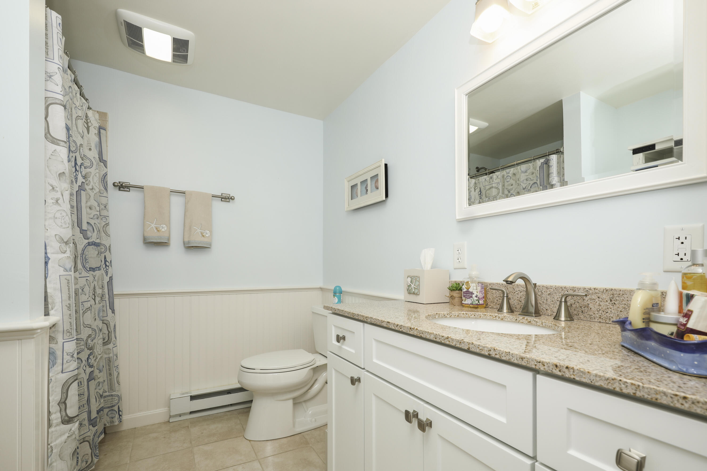 33 West Road, Unit 7B Orleans, MA 02653 - Photo 10 of 24 a bathroom with a granite countertop toilet sink and mirror