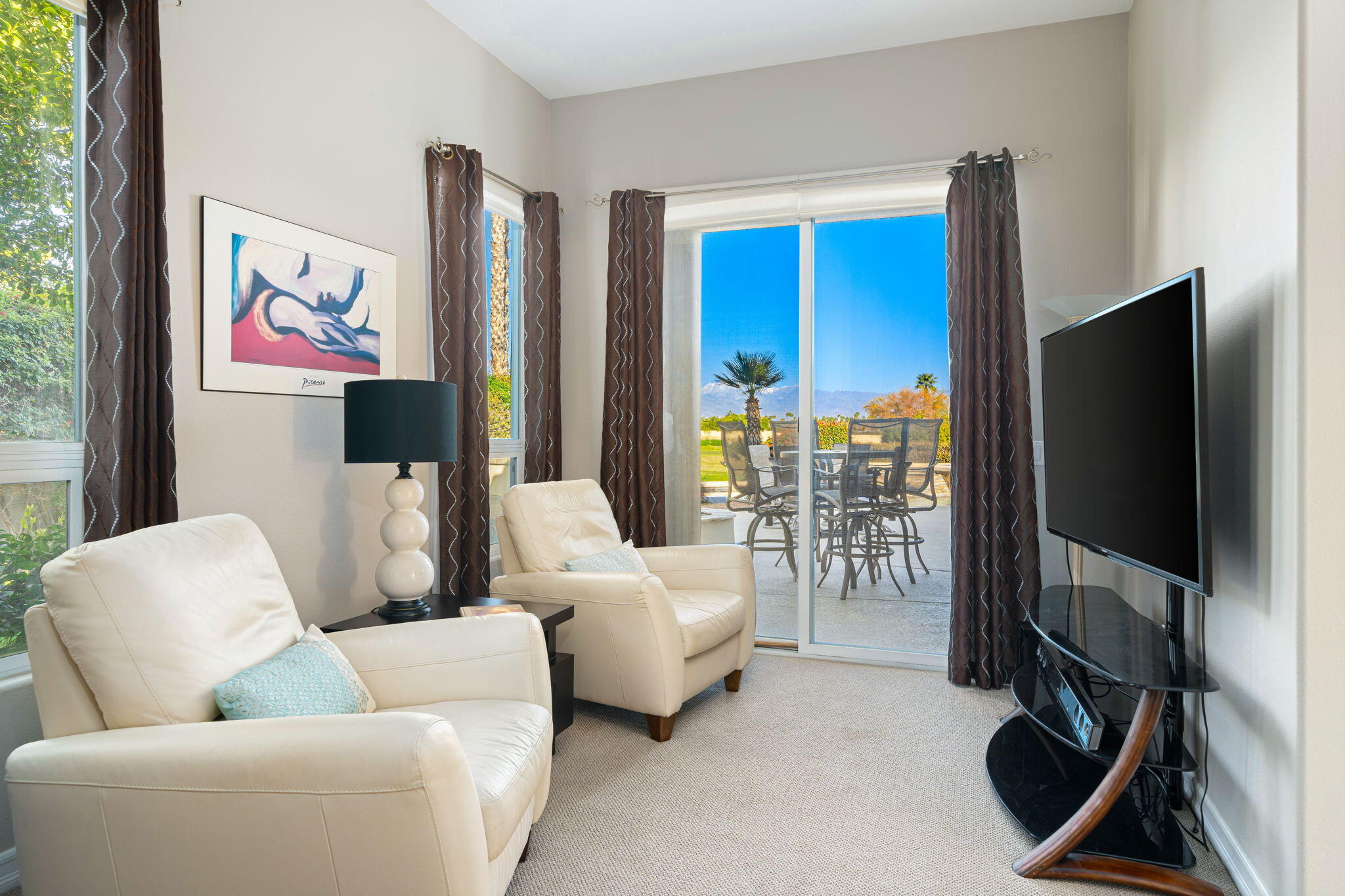 325 Loch Lomond Road Rancho Mirage, CA 92270 - Photo 39 of 49 a living room with furniture a flat screen tv and a floor to ceiling window