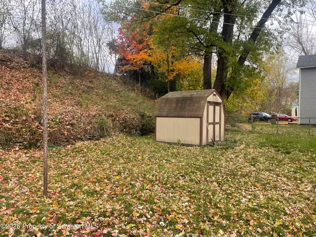 a backyard of a house with a garden and tree