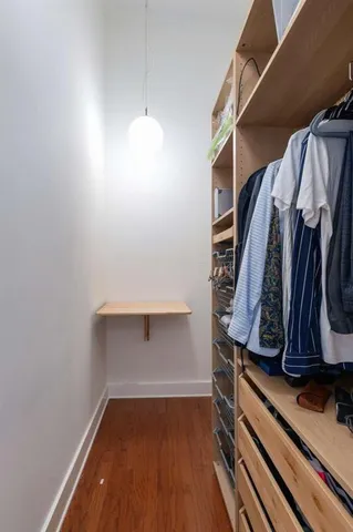 a view of walk in closet with clothes and shoes