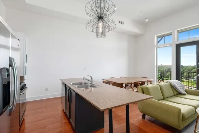 a kitchen with stainless steel appliances granite countertop a sink a stove and a refrigerator