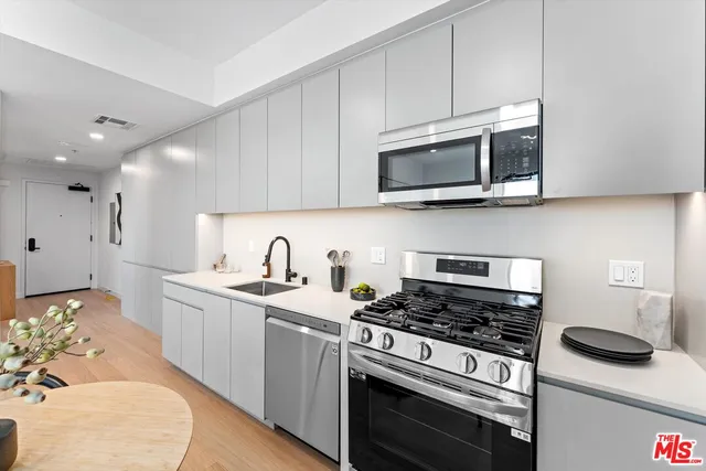a kitchen with stainless steel appliances granite countertop a stove and a microwave