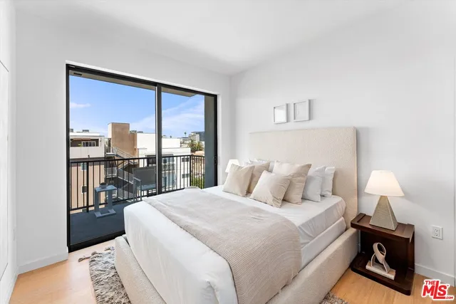 a bedroom with a large bed and a lamp next to a window