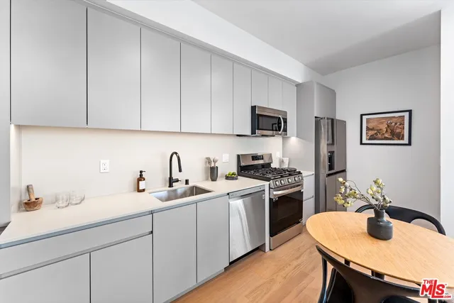 a kitchen with stainless steel appliances granite countertop a sink a stove a microwave a counter top space and cabinets