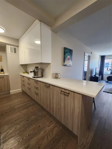 a kitchen with stainless steel appliances a sink cabinets and wooden floor