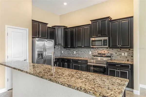 a kitchen with stainless steel appliances wooden cabinets a stove and a microwave