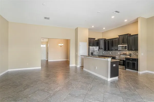 a large kitchen with stainless steel appliances a refrigerator and a stove top oven