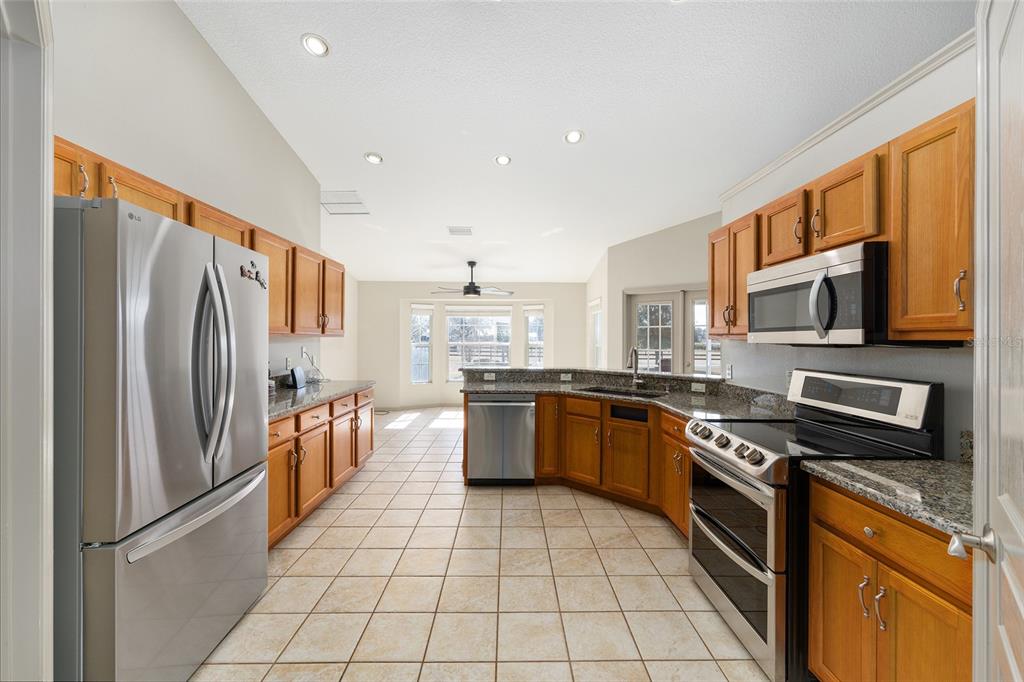 1120 East Highway 316 Citra, FL 32113 - Photo 13 of 61 a kitchen with stainless steel appliances granite countertop a refrigerator stove top oven and sink
