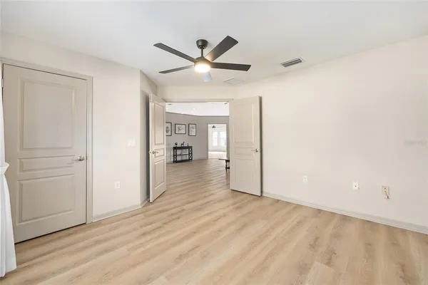 a spacious bedroom with a bed a couch and a chandelier