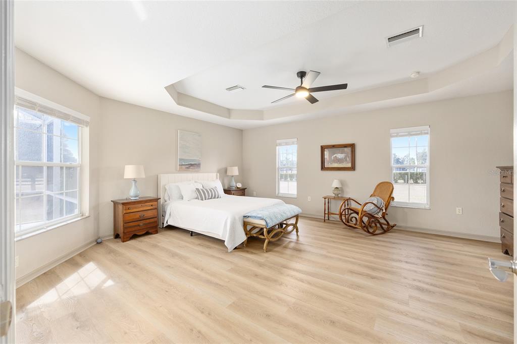 1120 East Highway 316 Citra, FL 32113 - Photo 23 of 61 a spacious bedroom with a bed a couch and a chandelier