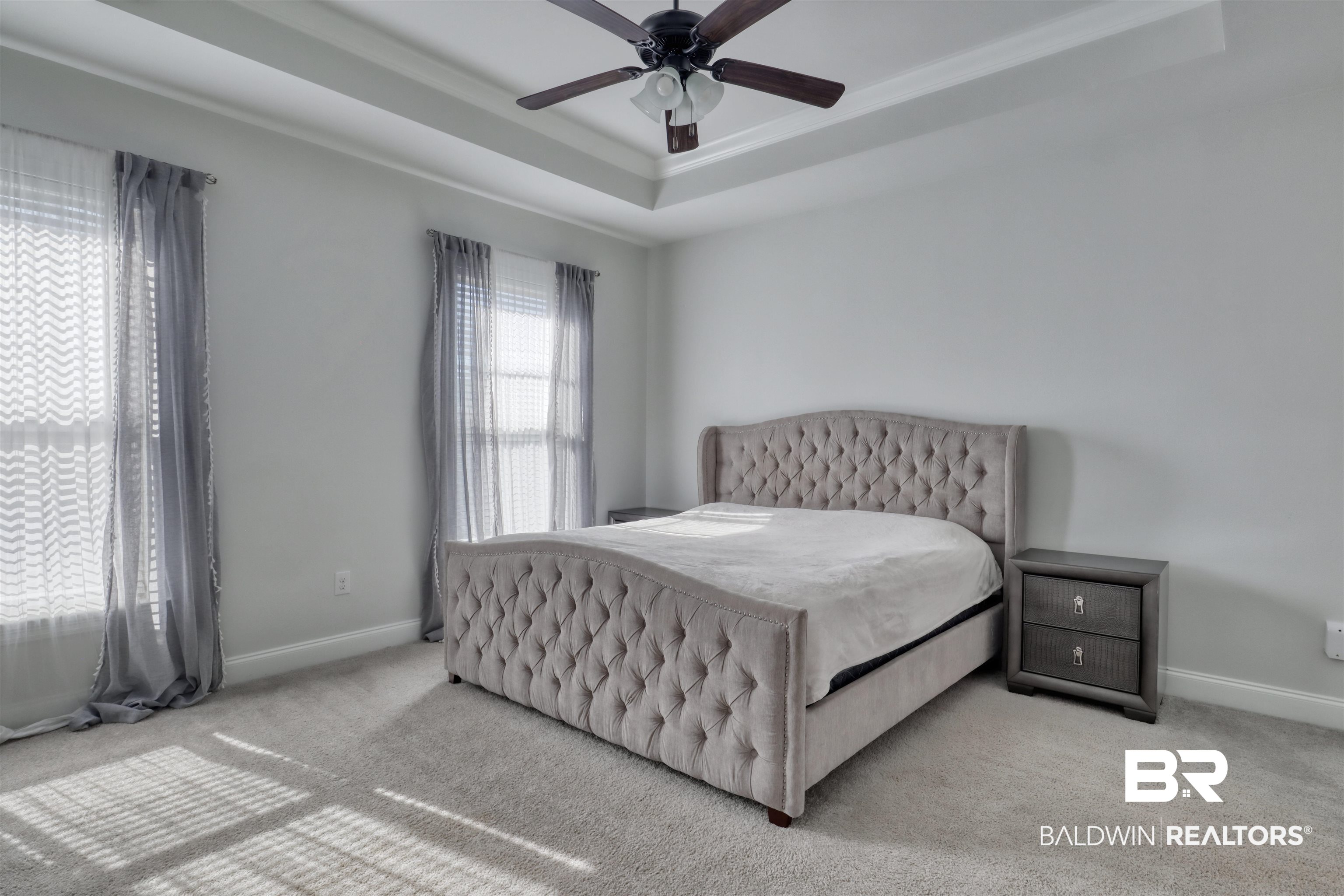 992 Dalton Circle Foley, AL 36535 - Photo 12 of 28 Bedroom featuring carpet floors, a ceiling fan, and a tray ceiling