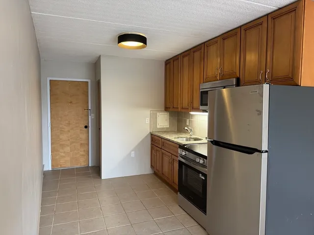 a kitchen with stainless steel appliances granite countertop a refrigerator and a stove