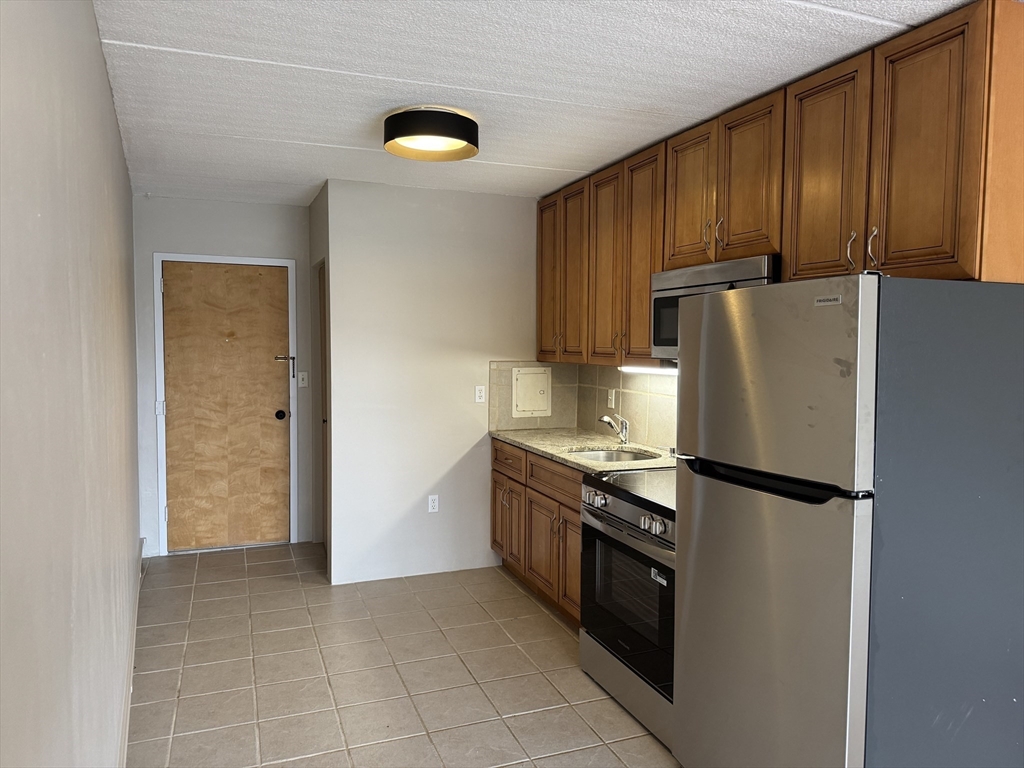 200 Swanton Street, Unit 234 Winchester, MA 01890 - Photo 3 of 17 a kitchen with stainless steel appliances granite countertop a refrigerator and a stove