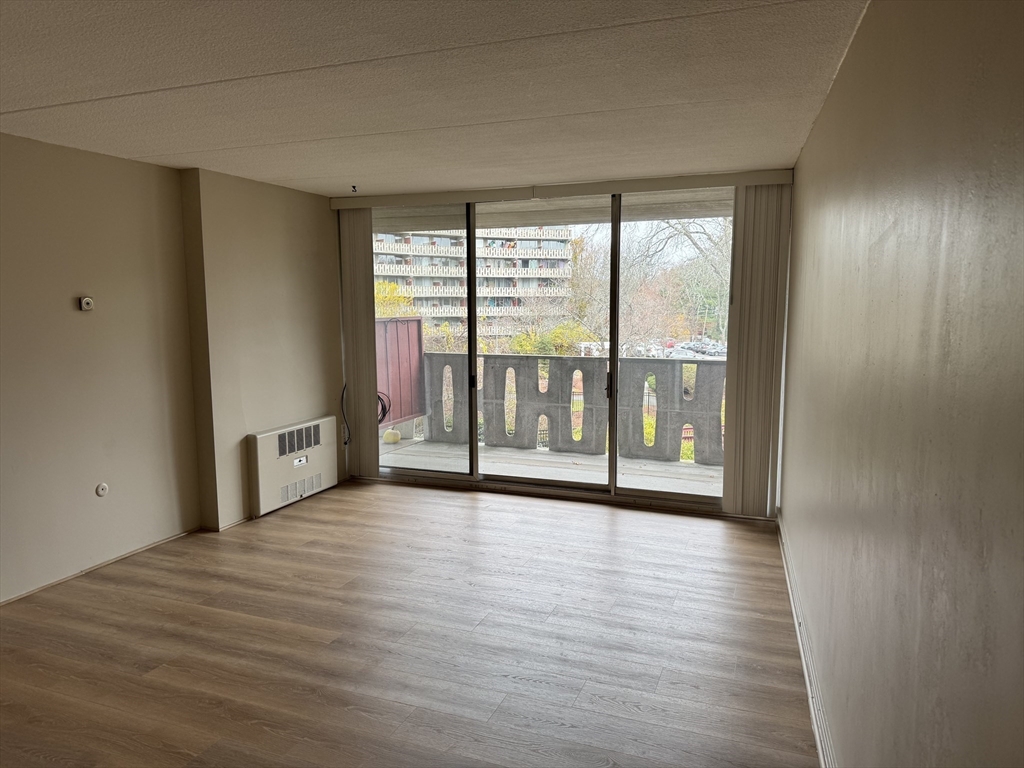 200 Swanton Street, Unit 234 Winchester, MA 01890 - Photo 5 of 17 a view of an empty room with wooden floor and a window