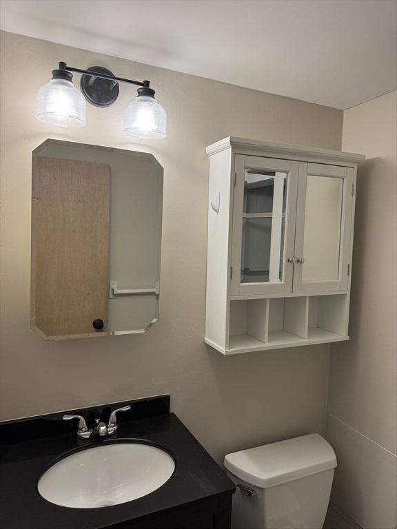 200 Swanton Street, Unit 234 Winchester, MA 01890 - Photo 8 of 17 a bathroom with a toilet a sink and mirror