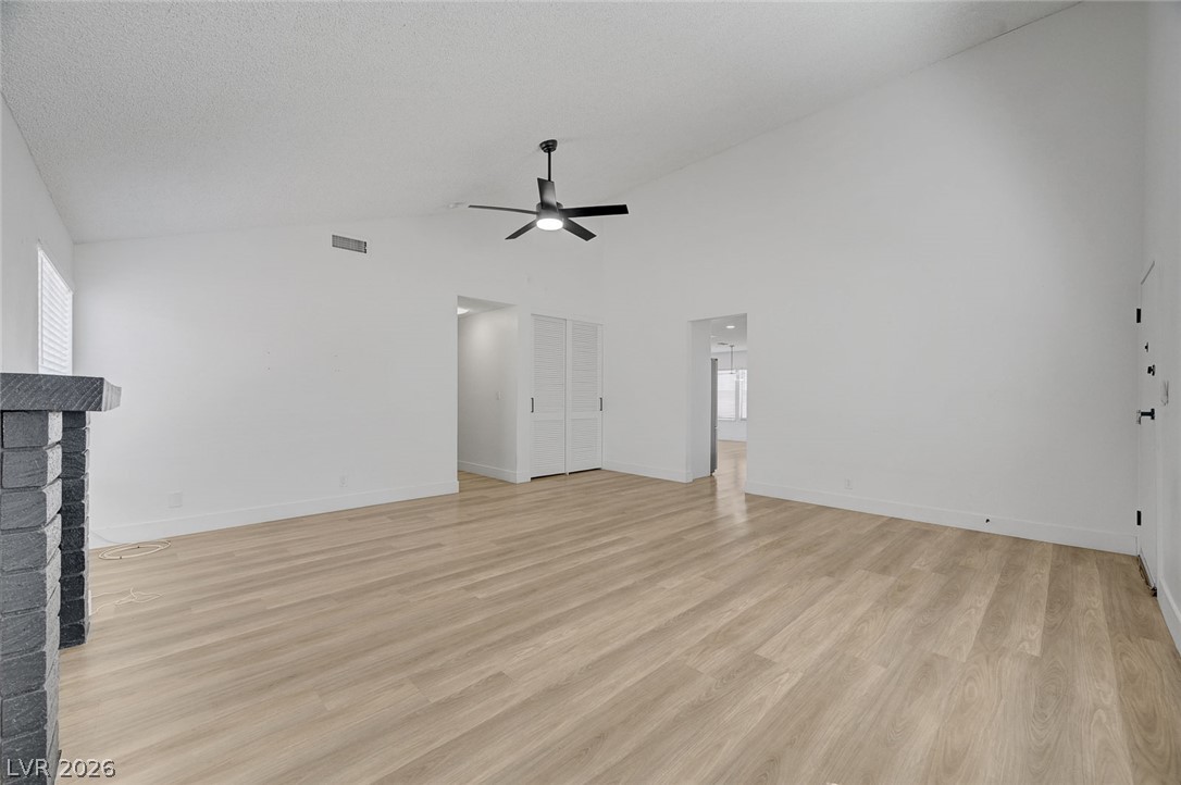 4840 Summerhill Road Las Vegas, NV 89121 - Photo 8 of 56 A spacious room features soaring vaulted ceilings and durable plank wood flooring.