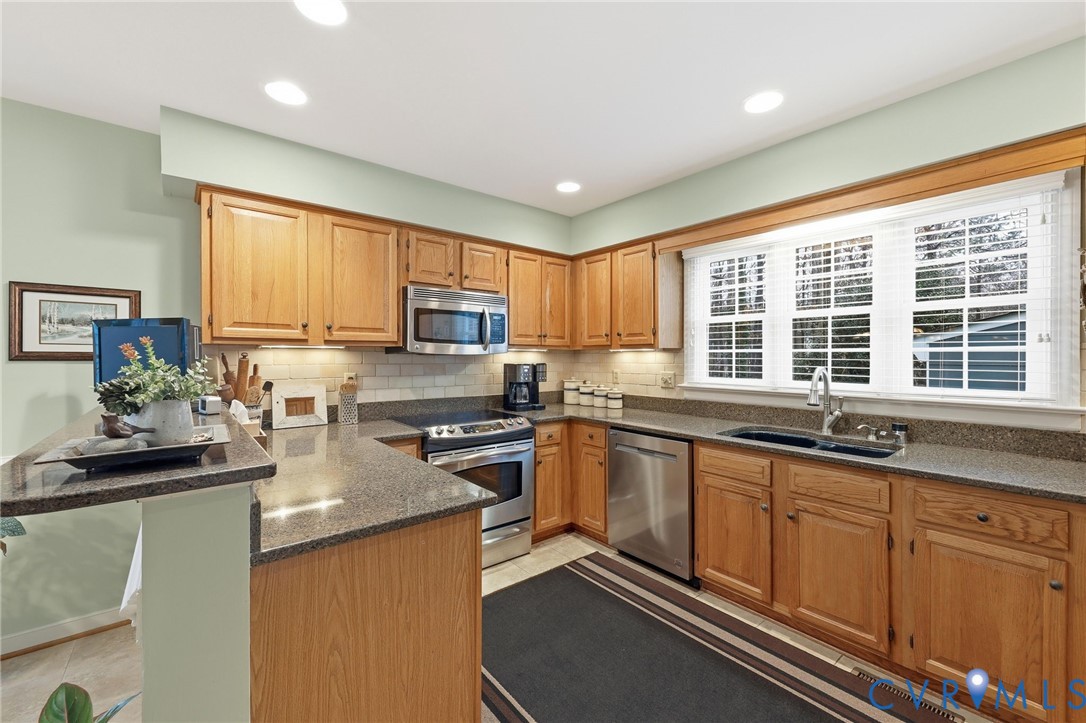 5601 Sandstone Ridge Road Midlothian, VA 23112 - Photo 11 of 43 a kitchen with stainless steel appliances granite countertop sink stove top oven and cabinets