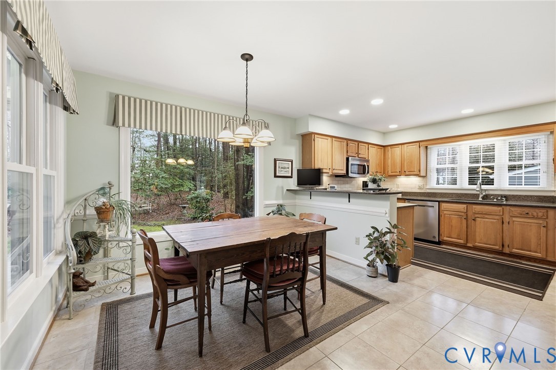 5601 Sandstone Ridge Road Midlothian, VA 23112 - Photo 10 of 43 a kitchen with a table chairs microwave and cabinets
