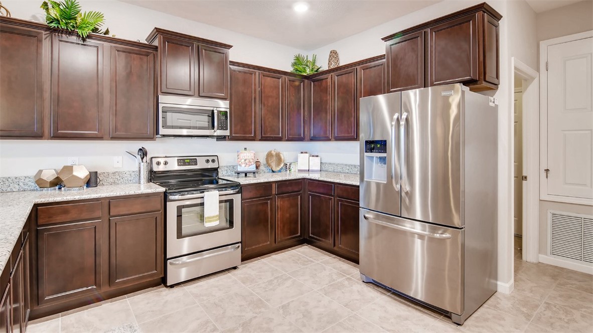 71 52nd Square Vero Beach, FL 32968 - Photo 2 of 16 a kitchen with stainless steel appliances granite countertop a refrigerator stove a sink and dishwasher