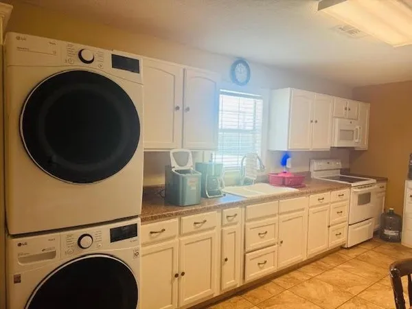 a kitchen with stainless steel appliances sink a washer and dryer