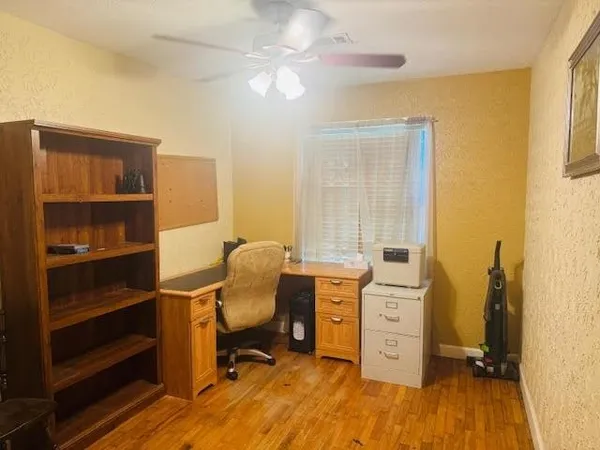 a view of a workspace with furniture and a window