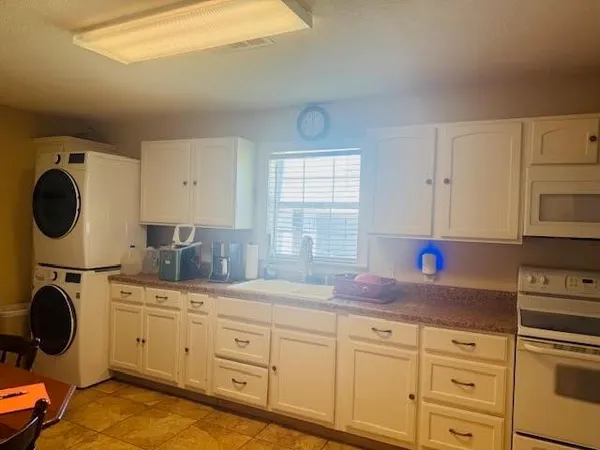 a kitchen with sink a stove and cabinets