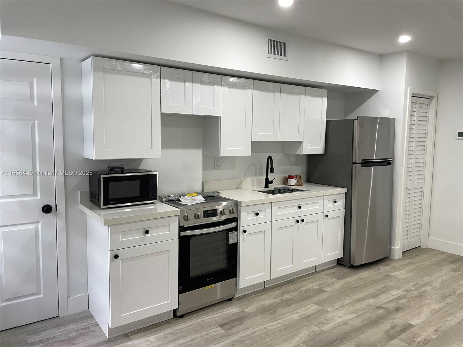 3034 Northwest 14th Avenue Miami, FL 33142 - Photo 3 of 8 a kitchen with a sink stove and refrigerator