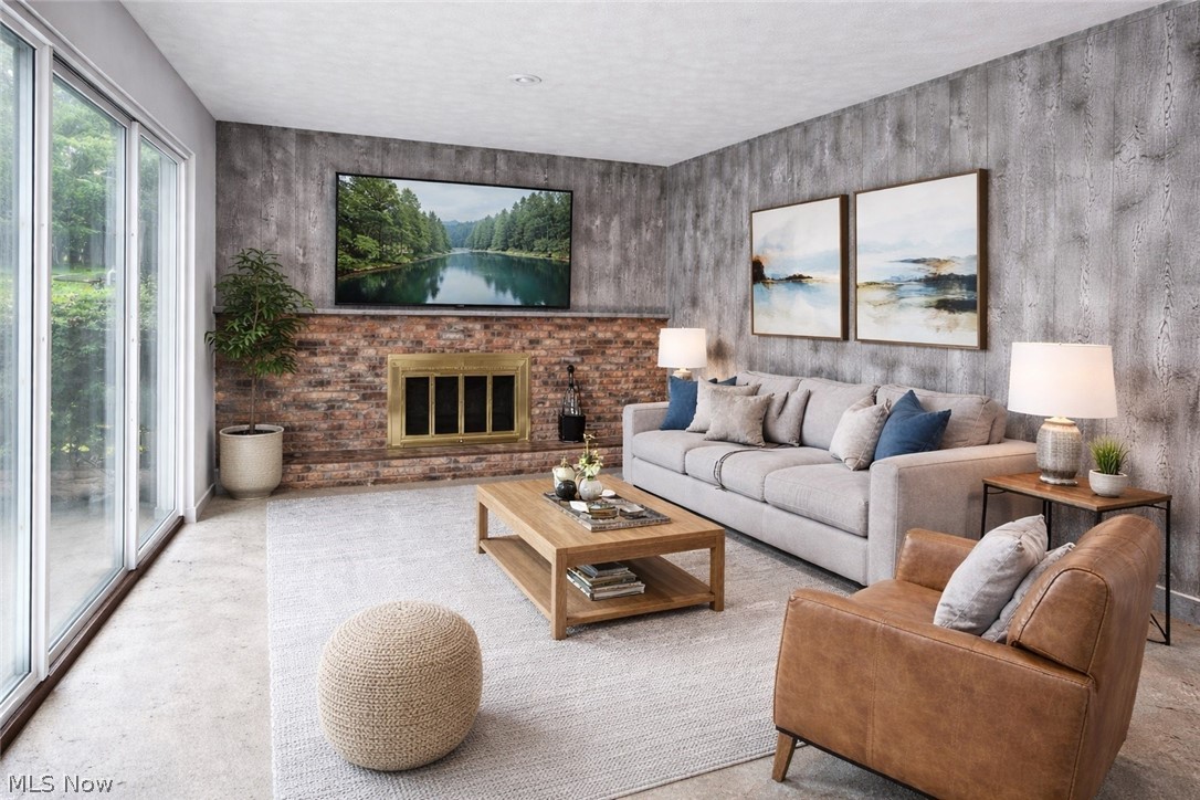 365 Sand Run Road Akron, OH 44313 - Photo 11 of 22 Living area featuring a brick fireplace with a brass insert, a wall-mounted display, and a full wall of sliding glass doors