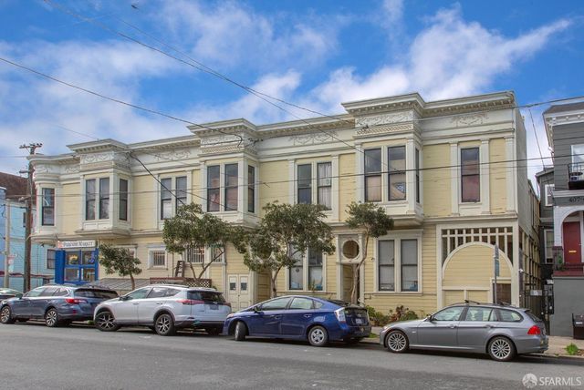 a couple of cars parked in front of a building