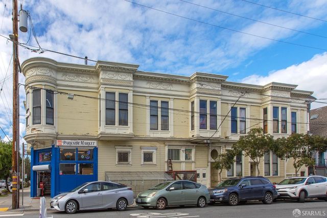 a front view of a building and car parked