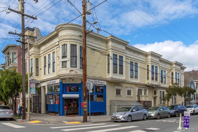 a front view of a building with parking space and plants