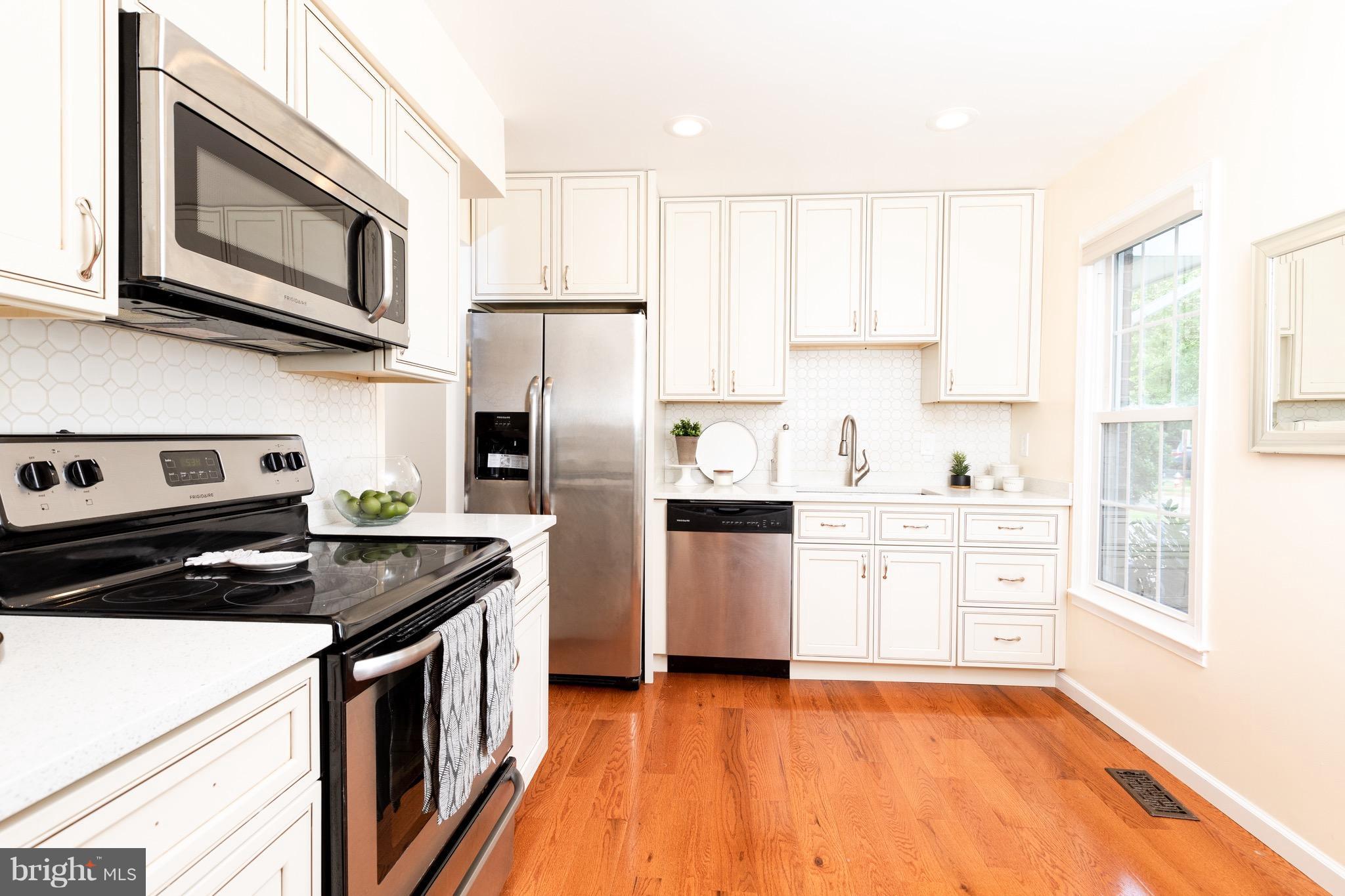 8586 Tyrolean Way Springfield, VA 22153 - Photo 2 of 18 a kitchen with a stove a sink and a microwave