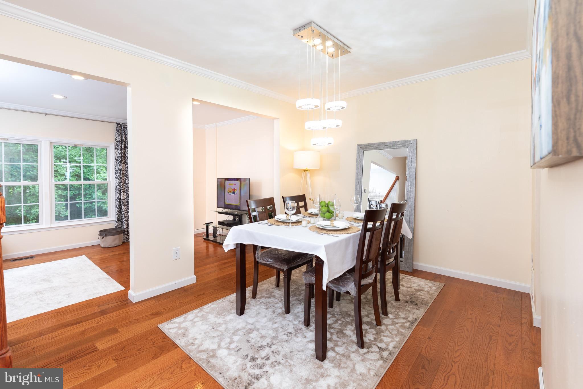 8586 Tyrolean Way Springfield, VA 22153 - Photo 7 of 18 a dining room with furniture a rug and wooden floor