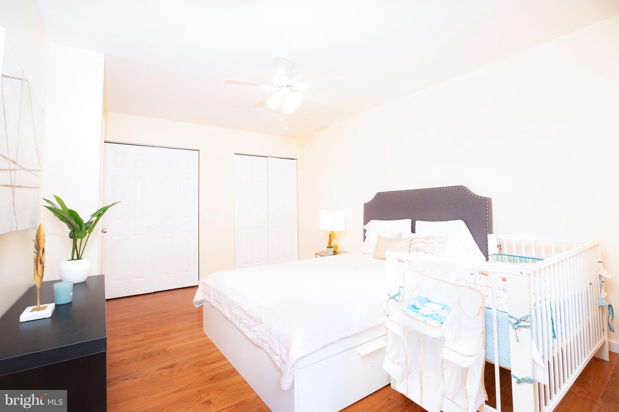 8586 Tyrolean Way Springfield, VA 22153 - Photo 9 of 18 a spacious bedroom with a bed and a potted plant