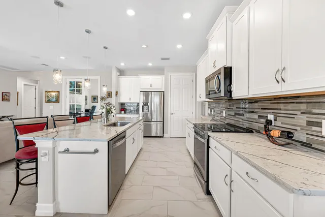 a kitchen with stainless steel appliances a sink stove and cabinets