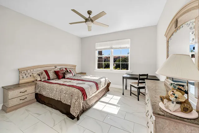 a spacious bedroom with a bed a table and chair