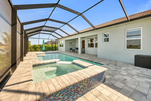 a view of a house with pool and sitting area